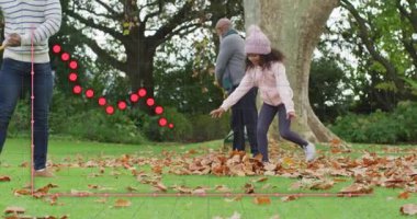 Yetişkin ve kıdemli erkekler tırmık kullanarak bahçe işlerini başlatırken kızların yaprakları kepçeleyip atmasını sağlıyor. Aile, açık hava, mevsimlik, boş zaman, birliktelik, hareketli, kırsal