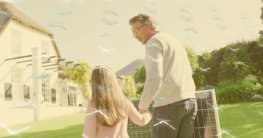 Baba kızının elini tutuyor ve pergola 'ya doğru güneş panelini taşıyor. Aile, sürdürülebilirlik, açık hava, teknoloji, çevre, uyum, eğitim