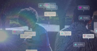 Mavi tişörtlü gülümseyen kadın parkta işaret fişeği, mikrofon teçhizatı ve medya ikonlarıyla telefon titreşimlerini ayarlıyor. İşbirliği, sosyal medya, açık hava, şehir, teknoloji, ağ, yenilik