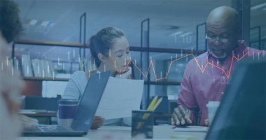 Gri bluzlu kadın ve düğmeli gömlekli adam açık planlı masada dizüstü bilgisayarlarla belgeleri inceliyor. İşbirliği, takım çalışması, çalışma alanı, modern, profesyonel, beyin fırtınası, iletişim