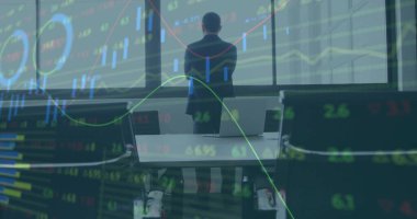 Chinese executive wearing dark suit analyzing stock chart overlays in boardroom, with laptops. Finance, technology, analytics, corporate, investment, data visualization, futurism