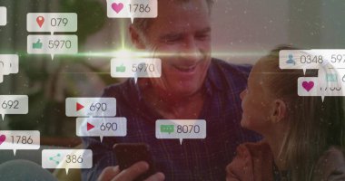 Sosyal medya ikonlarıyla arka bahçedeki verandada dedem ve torunum telefonları kaydırıyor. Aile, nesil, bağlantı, teknoloji, açık hava, eğlence, mutluluk