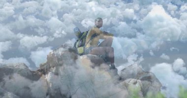 Kayalık zirvede sırt çantası ve yuvarlanmış uyku paspası ile ufka doğru bakan erkek yürüyüşçü. Macera, keşif, vahşi doğa, azim, yalnızlık, dağ, açık hava