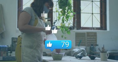 Stüdyoda karatahta tabelası ve fotokopi odası olan önlük kaplama kabı takan seramik sanatçısı. Sanatçılık, zanaat, yaratıcı, el yapımı, stüdyo, estetik, dokunsal