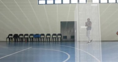 Antrenör, atletlerin atımlı bulut örtüsü altında sürtünmelerini ve ayak sürümelerini izleyip, talim sinyali veriyor. Spor, takım çalışması, fitness, eğitim, yenilik, modern, atletik