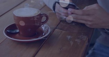 Kafe masasında akıllı telefonu dinleyen adam analitik analiz için kahve fincanının üzerinden yükselen canlı veri grafiklerini izliyor. Teknoloji, veri görselleştirme, analitik, dijital arayüz, modern, iletişim, yenilik