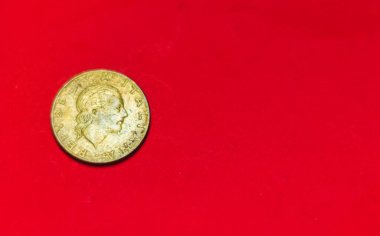 İtalyan 200 lireti. Eskinin arka tarafı. 1983 'te 200 İtalyan lirası kullanılmış. Kırmızı arka planda izole edilmiş klasik bronz para ve metin kopyası için boşluk. repvbblica italiana 200
