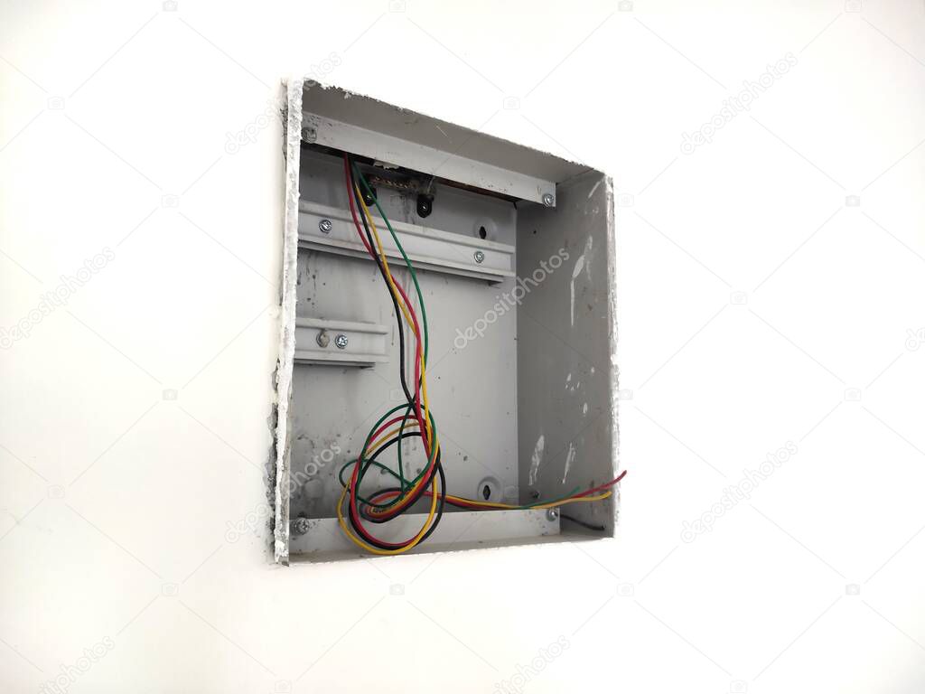 unfinished electrical steel junction box on white brick wall. Household electric installation work, home wiring repair. Upgrade the power system in the house.Wires, switch box and socket on wall.