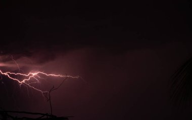 Şehir binaları üzerinde şimşek fırtınası. Metropolitan şehrinde bir fırtına sırasında yıldırım düştü. Parlak elektrik şimşekli karanlık gökyüzü, gök gürültüsü ve şimşek, kötü hava konsepti