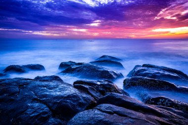 Sahilde güzel bir güneş doğuyor. Gün doğumunda Hindistan 'daki Rocky Beach' ten hareketli elementler ve dalga fotoğrafçılığı. Bengal körfezinde kızıl gökyüzü, yavaş çekim yapan deniz dalgaları ve kayalar..