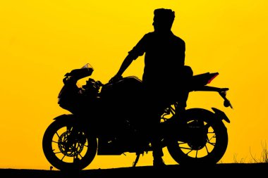 Chennai, Hindistan - 8 Mart 2019: kasksız motosikletli genç motorcunun silueti. Motosikletli motorcunun kaskı yok. Siluet gündoğumu arka planında izole edilmiş..