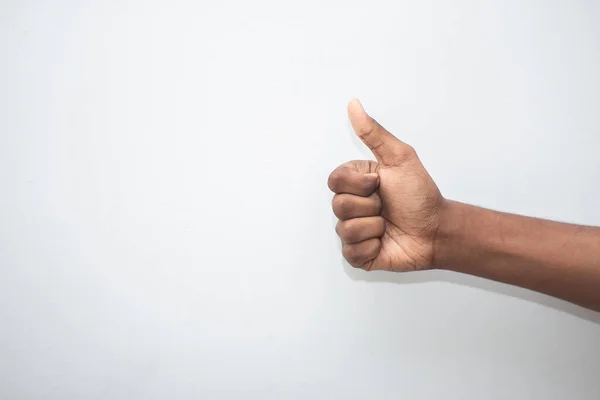Thumbs up sign - Male hand showing thumbs up sign isolated on white background. Hand symbol sign language.