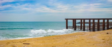 Yıkılmış deniz köprüsü olan güzel bir deniz manzarası. Sabah Sahil Manzarası ve Yok Olan İskelenin Önplanı.