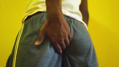 Itching buttocks - Causes of butt rashes in adults . Young man rude scratches his buttocks indoor - NOT something to do in outside public places. Itching the Buttocks, Healthcare Concept.