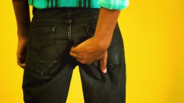 Itching buttocks - Causes of butt rashes in adults . Young man rude scratches his buttocks indoor - NOT something to do in outside public places. Itching the Buttocks, Healthcare Concept.