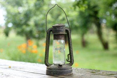 Kulübede asılı eski ve paslı gaz lambası arka planda Bokeh var.