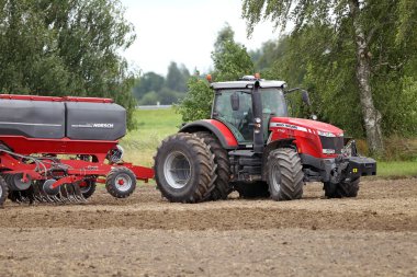 Çiftçi tarlayı sürüyor tarlada traktör yetiştiriyor tarla traktörü tarla traktörü ve tarla sürücüsü ile tarlayı sürüyor. Litvanya