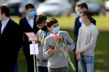Maske takan öğrenciler ve öğretmenler okula döndüklerinde kendilerini koronavirüsten korurlar. Salgından sonra, öğrenciler yeni okul yılına hazırlanmak için okula geri dönüyorlar. Kedainiai Meslek Eğitim Merkezi. Litvanya