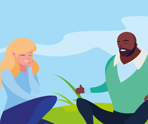 межрасовая молодая пара, сидящая в поле
