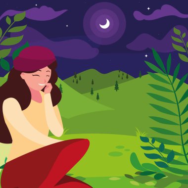 Gece tarlada oturan bereli bir kadın.