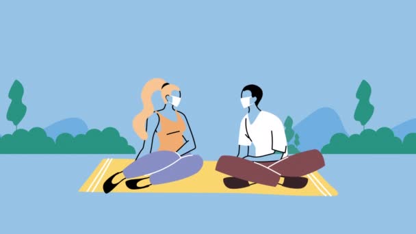 Young couple wearing medical masks for covid19 prevention seated in the park — Stock Video