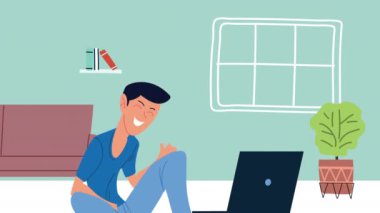 Genç adam yerde oturan dizüstü bilgisayarı kullanarak tele-iş yapıyor.