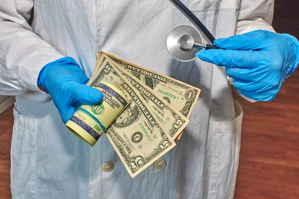 doctor in gloves and a fanendoscope in cash bills, corruption in the hospital, non-fulfillment of the Hippocratic oath, criminal negligence