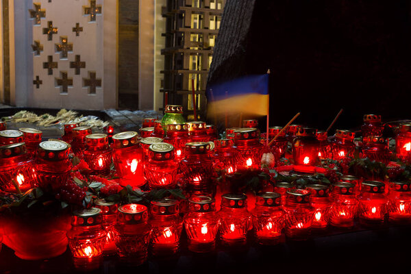 Red candles at night near the holodomor memorial.