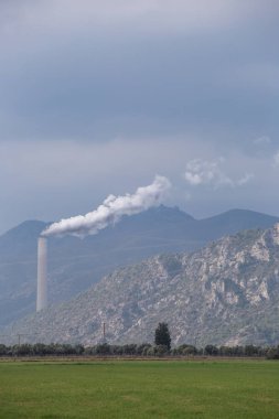 Çevre Kirliliği. Beyaz buhar borudan geliyor. Endüstri fabrikası sahada. Yatay arka plan.