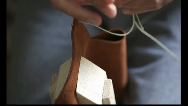 Macro schieten van proces lederen naaizak details, handen met naald, workshop op zadelmaker — Stockvideo