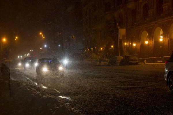Winter snow storm. Traffic jam at night. Car blurred at the street. Royalty Free Stock Images