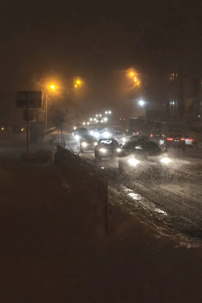 Winter snow storm. Traffic jam at night. Car blurred at the street. — Stock Photo, Image