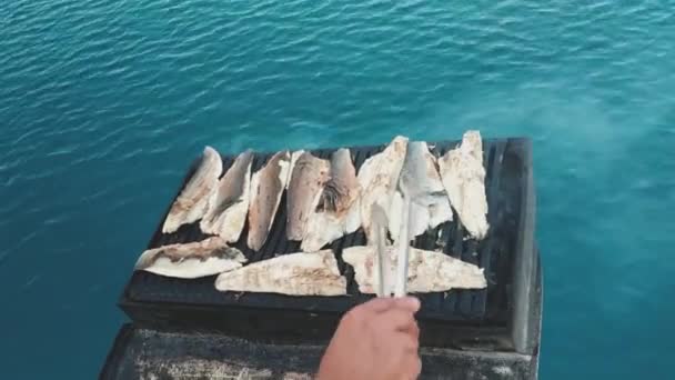 Homem mão transformando peixe no churrasco, mangal sobre o mar aberto no barco. — Vídeo de Stock