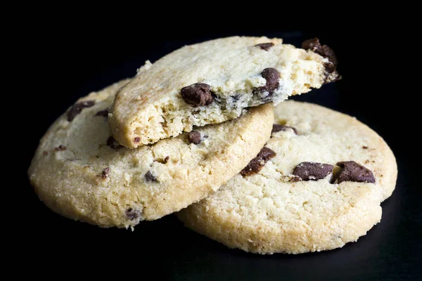 Round chocolate chip shortbread biscuits. On black. — Stock Photo, Image