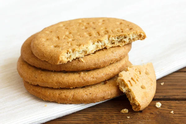 Montón de galletas digestivas de harina dulce en madera oscura y servilleta . — Foto de Stock