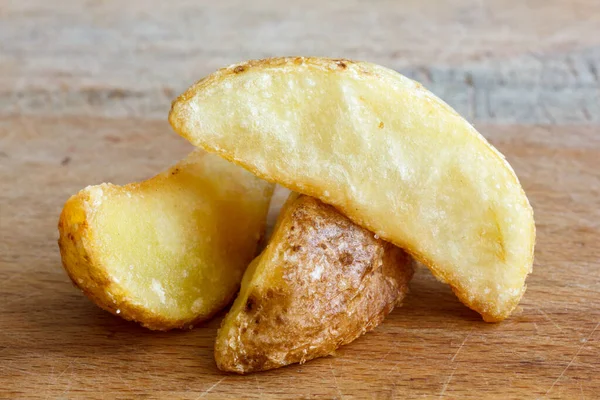 Detalhe de fatias de batata frita isoladas em tábua de madeira rústica . — Fotografia de Stock