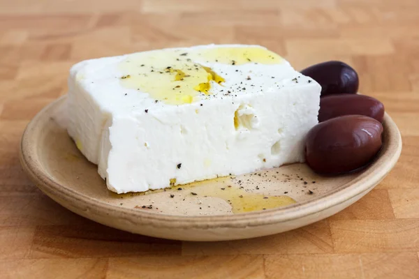 Греческий сыр фета, масло, оливки каламата на деревенской доске . — стоковое фото