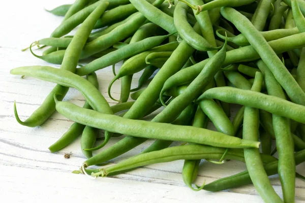 Whole French green string beans  on white rustic wood. — Stock Photo, Image