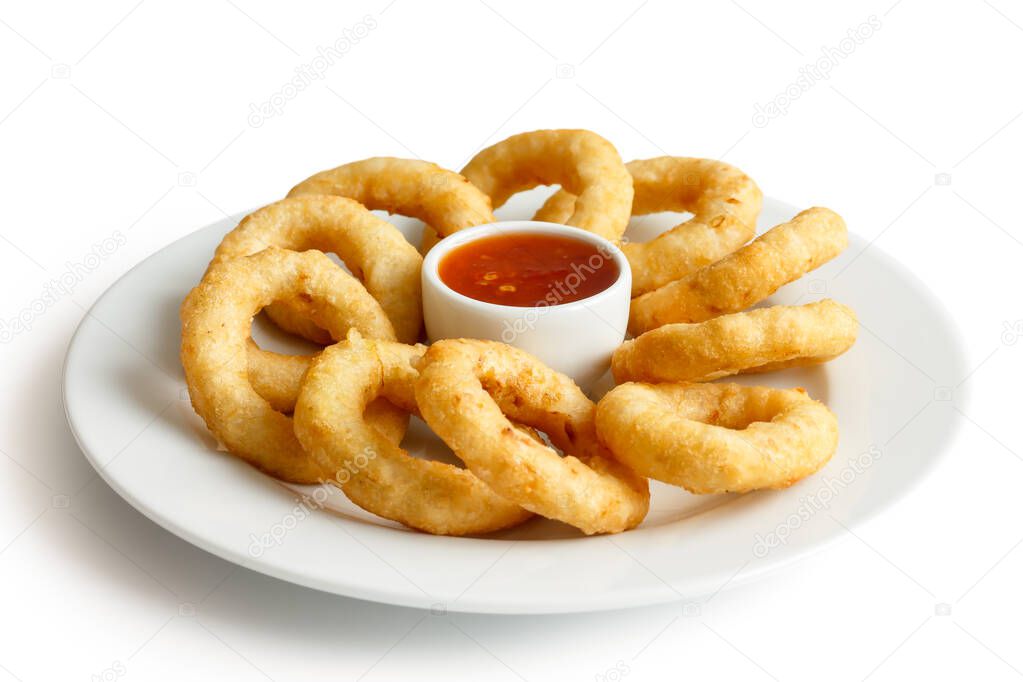 Heap of deep fried onion or calamari rings with chilli dip on wh