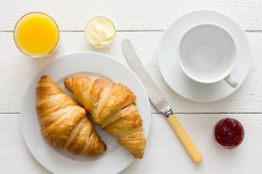 Kahve, portakal suyu ve kruvasan kahvaltısı. Yukarıdan.