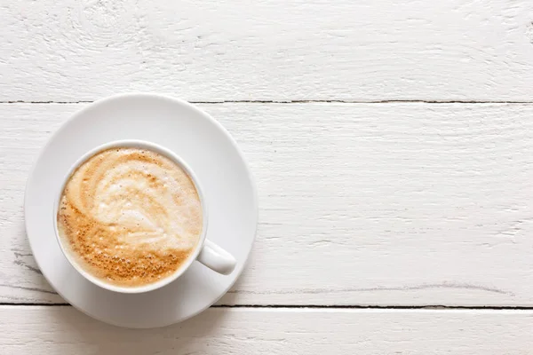 Cappuccino dalam cangkir pada kayu pedesaan dicat. Dari atas . — Stok Foto