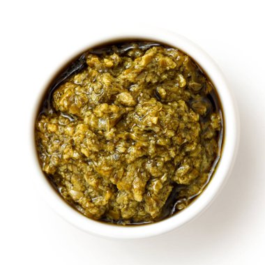 Beyaz fro üzerinde izole edilmiş seramik kasede Sicilya usulü fesleğen pesto