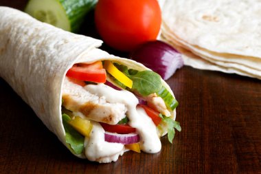 Izgara tavuk ve salata, beyaz soslu tortilla dürümü.