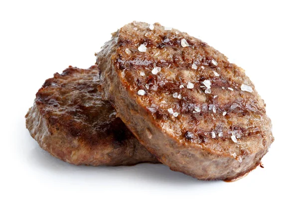 Two grilled hamburger patties with salt isolated on white. — Stock Photo, Image