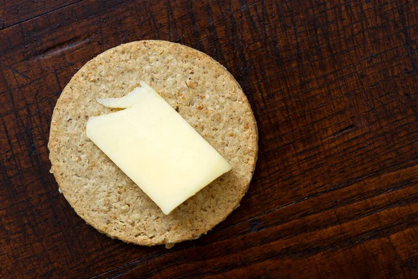 Single Scottish oatcake with a slice of yellow cheese isolated o — Stock Photo, Image