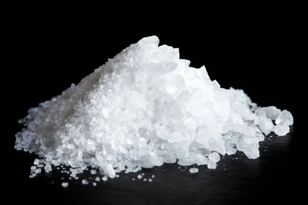Heap of fine and coarse salt isolated on black. Royalty Free Stock Photos