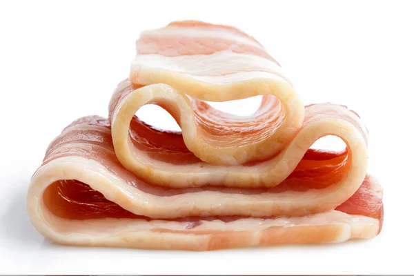 Faixa única de bacon entremeado não cozido dobrado isolado em branco . — Fotografia de Stock