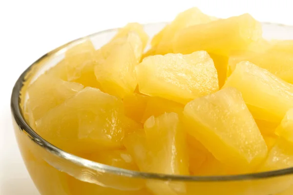 Pezzi di ananas in scatola in una ciotola di vetro su bianco . — Foto Stock