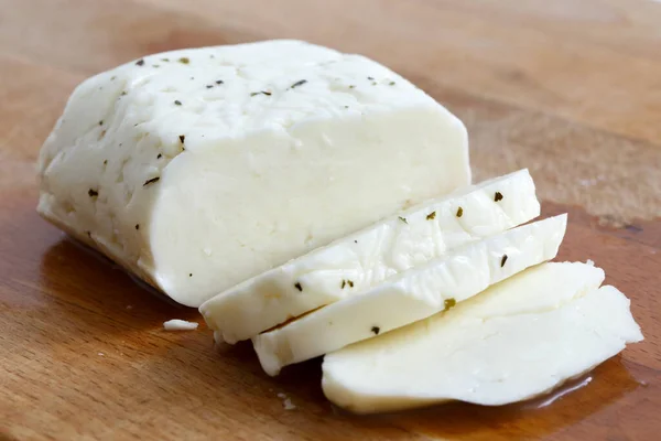 Brânză feliată halloumi cu mentă pe placa de lemn în perspectivă . — Fotografie, imagine de stoc