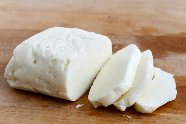 Brânză feliată halloumi pe placa de lemn în perspectivă . — Fotografie, imagine de stoc